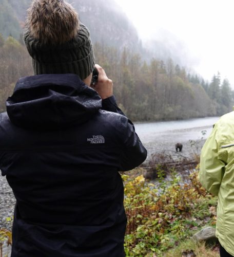 Woman viewing grizzly bear with camera