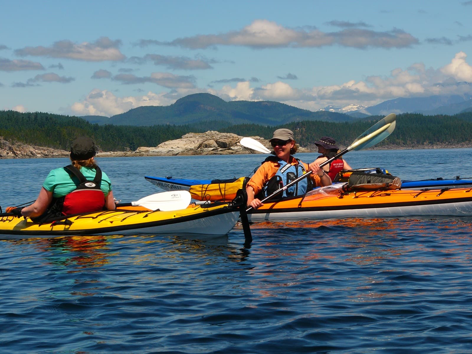 Discovery Islands Kayaking Three kayakers talking to each other in calm water