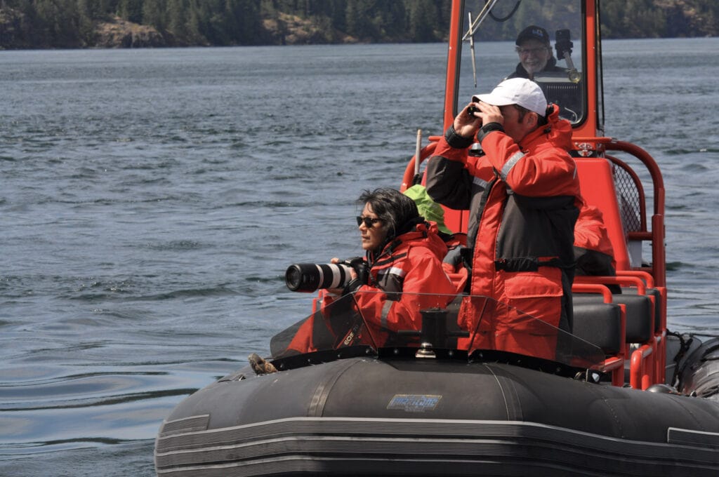 two people in an inflatable boat on the water