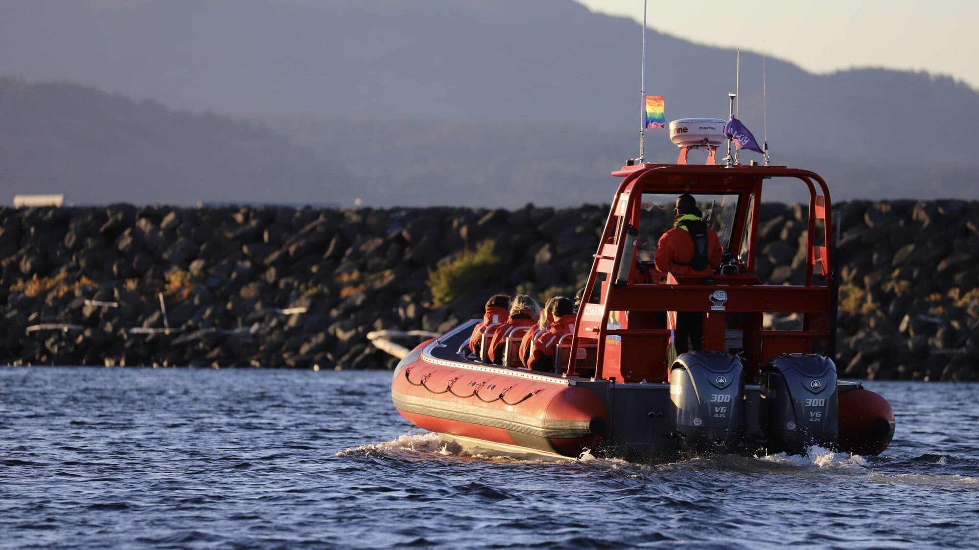 Zodiac at sunset with rainbow flag