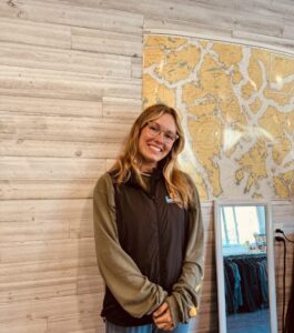 Staff member Lexie standing next to map at office.