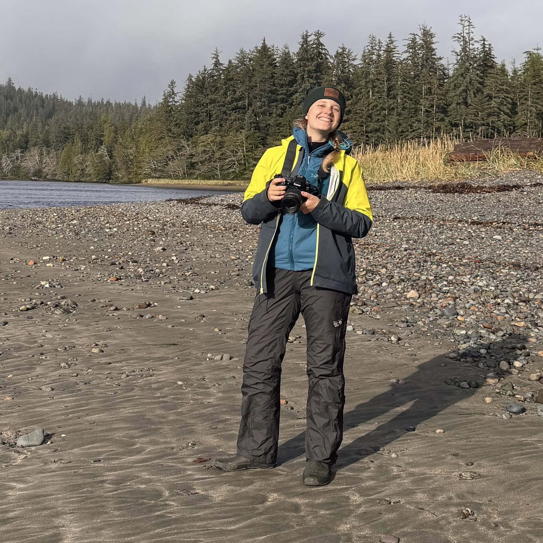 Staff member Rosalie standing on sandy shore.